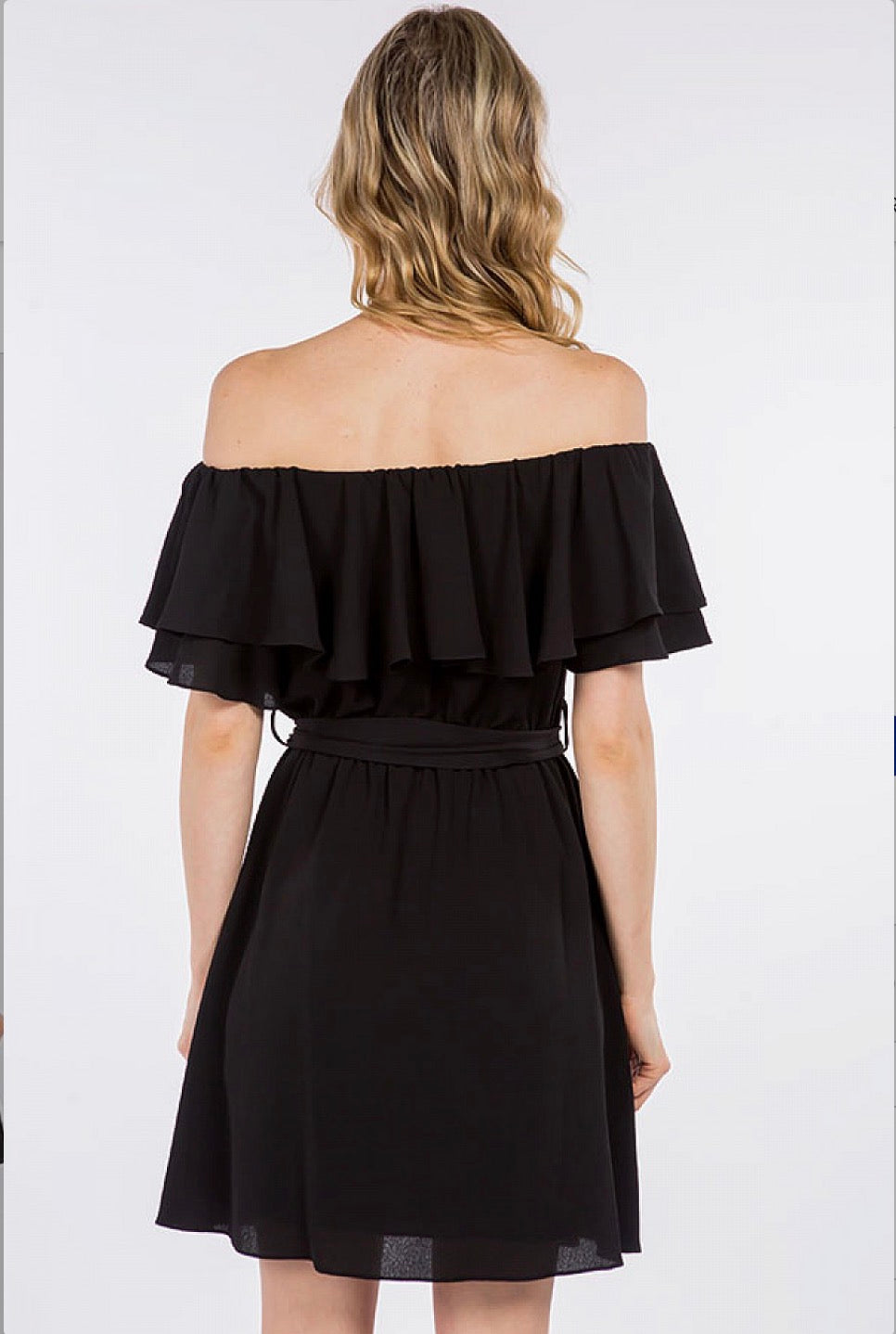 A woman wearing a black Off Shoulder Ruffle Dress by Spin USA.