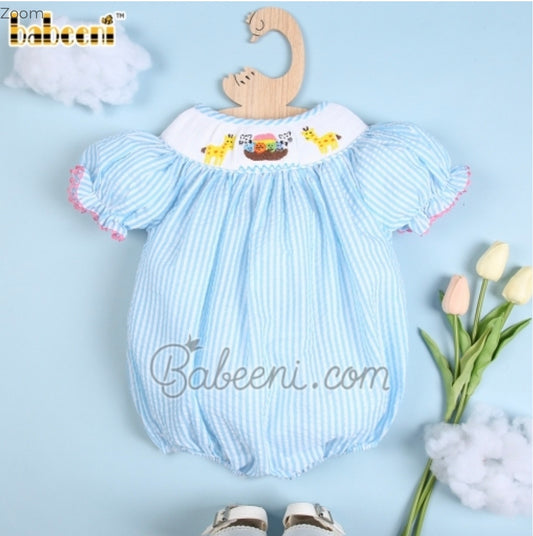 A Babeeni Hand Smocked Noah's Ark Bubble outfit and shoes for a baby boy in blue and white.