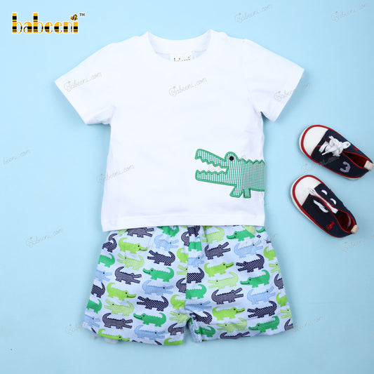 A Babeeni Alligators Applique 2-Piece Set for Boys - Stylish and Comfortable Outfit and shoes on a blue background.