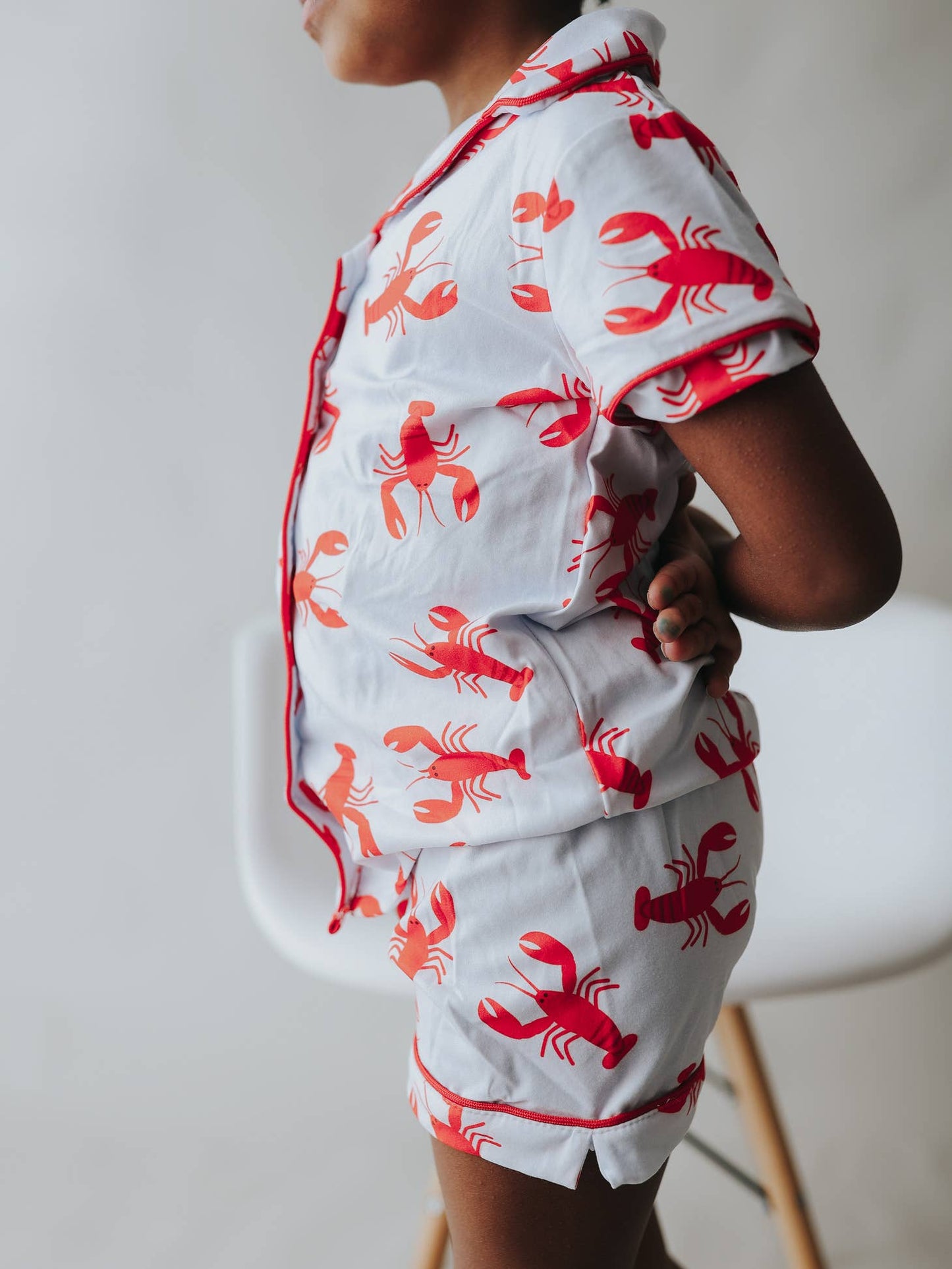 A little girl in Sugar Bee Clothing's Crawfish Button Down Pajamas.