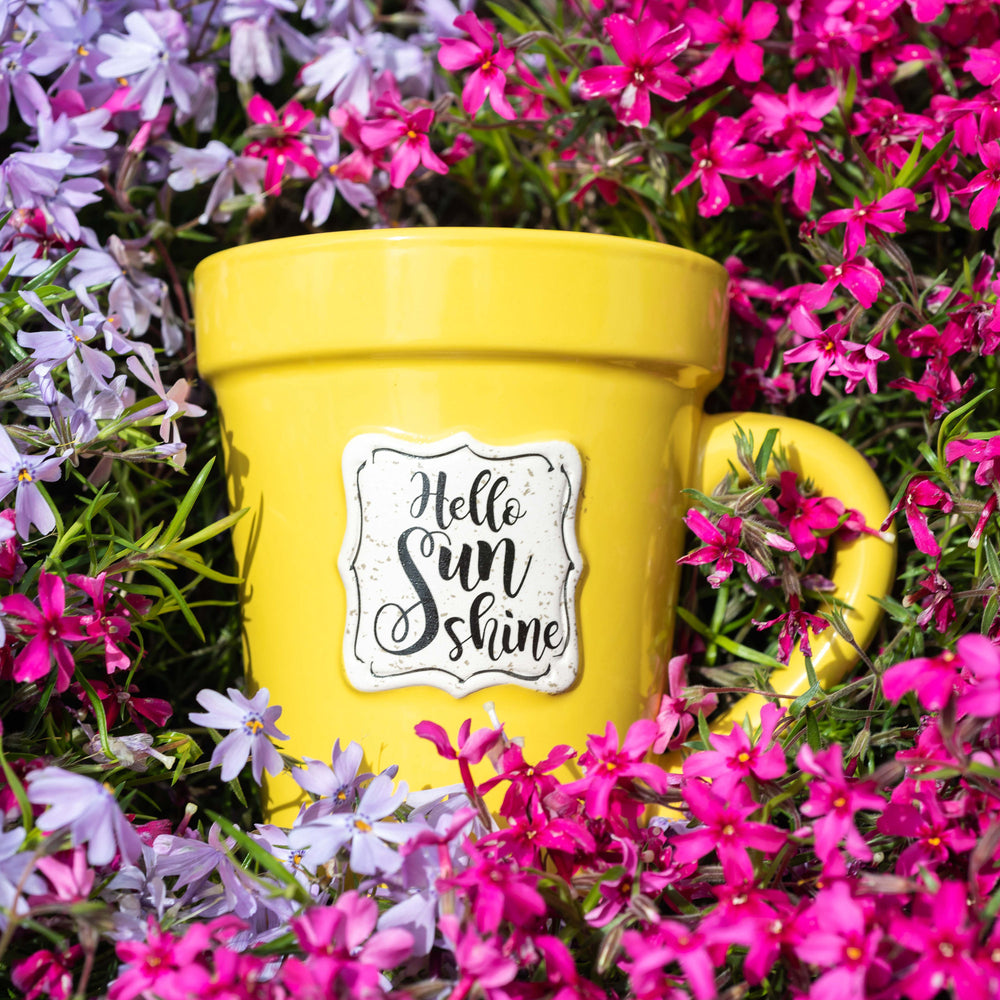 A Yellow Flower Pot Mug - Hello Sunshine surrounded by purple flowers. (Brand: Nicole Brayden)
