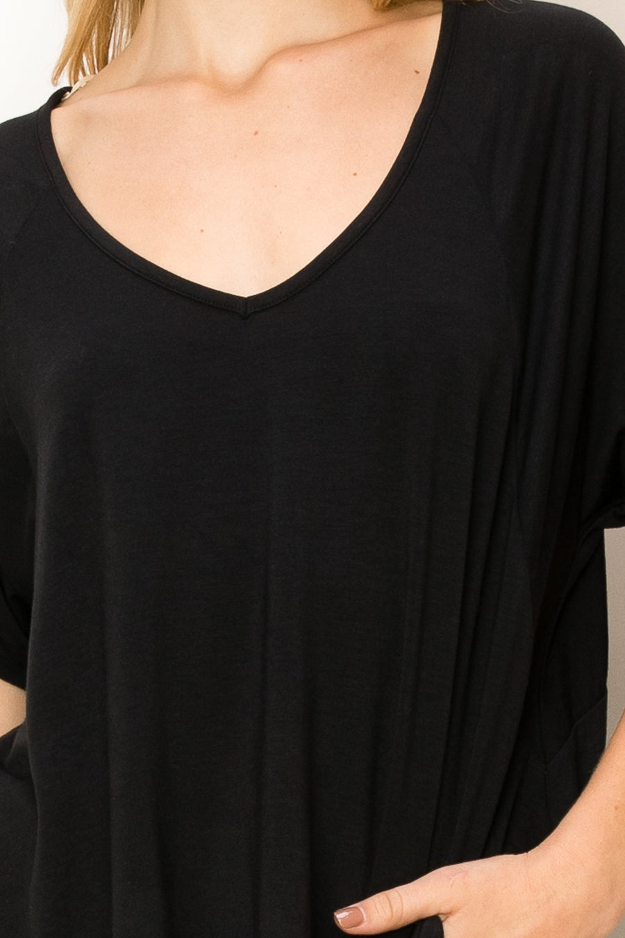A woman wearing a HYFVE Oversized Short Sleeve Top with a v-neck.