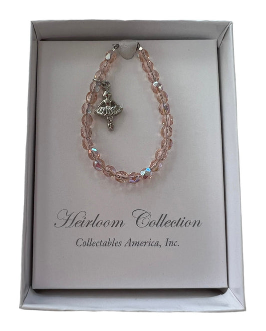 A Pink Crystal Ballerina Bracelet from Collectables America in a box with a charm on it.