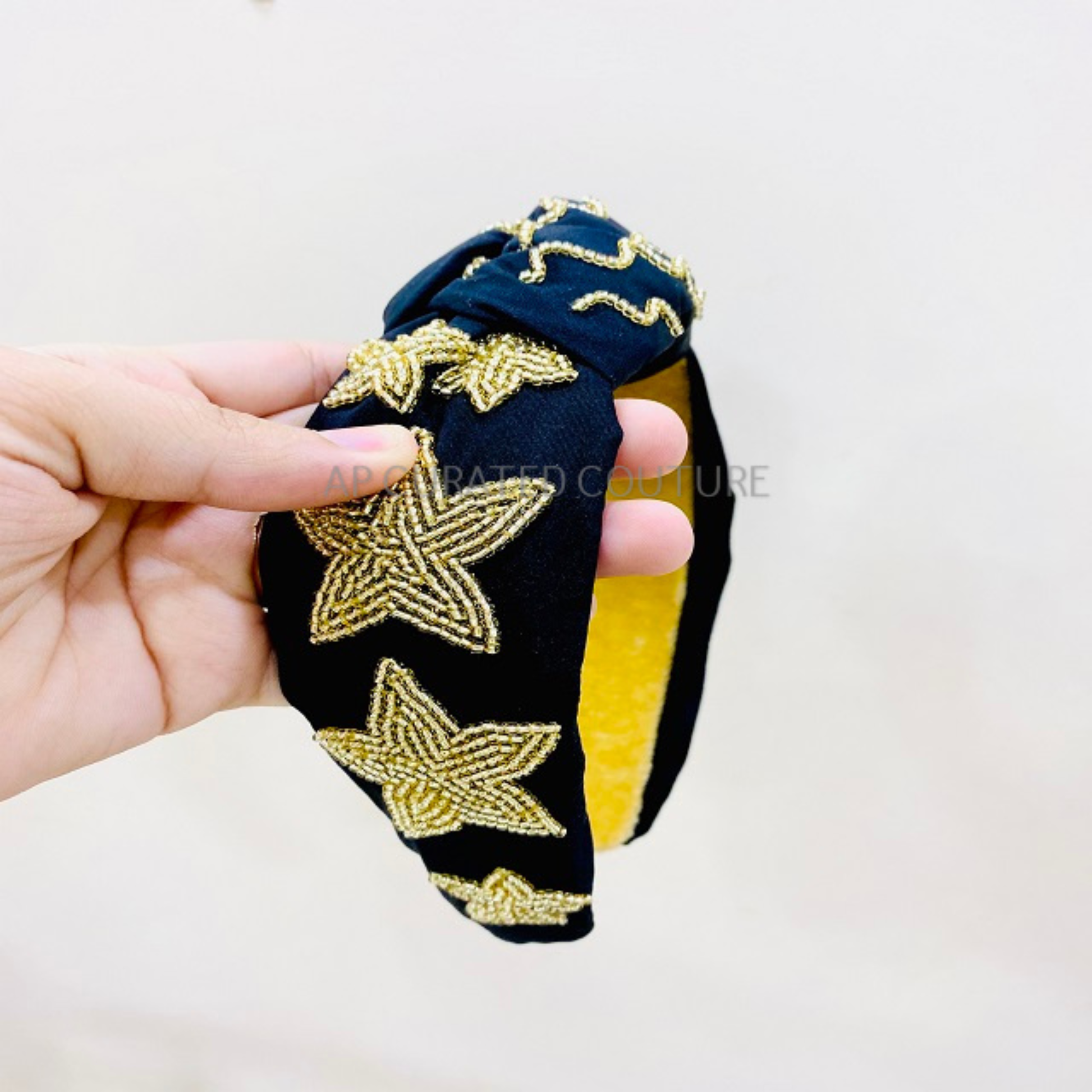 A person wearing a Bash New Orleans Football Headband with Black and Gold Stars, excited for game day.