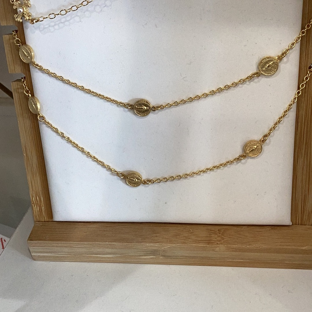 A 16-18' inch 3 double sided mary necklace on a wooden stand by Weisinger Designs.