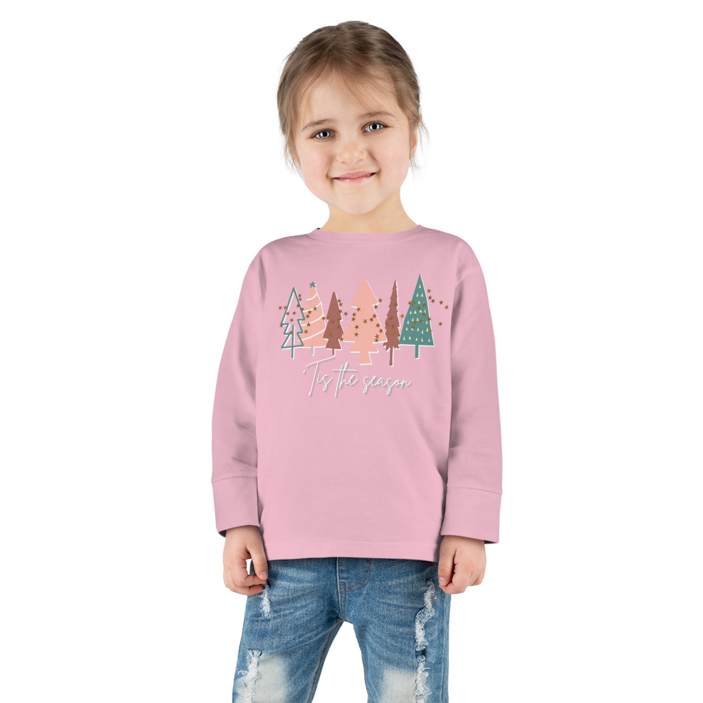 A girl wearing a pink long-sleeve t-shirt with trees on it, available in our Printify store for Kids and Parents.