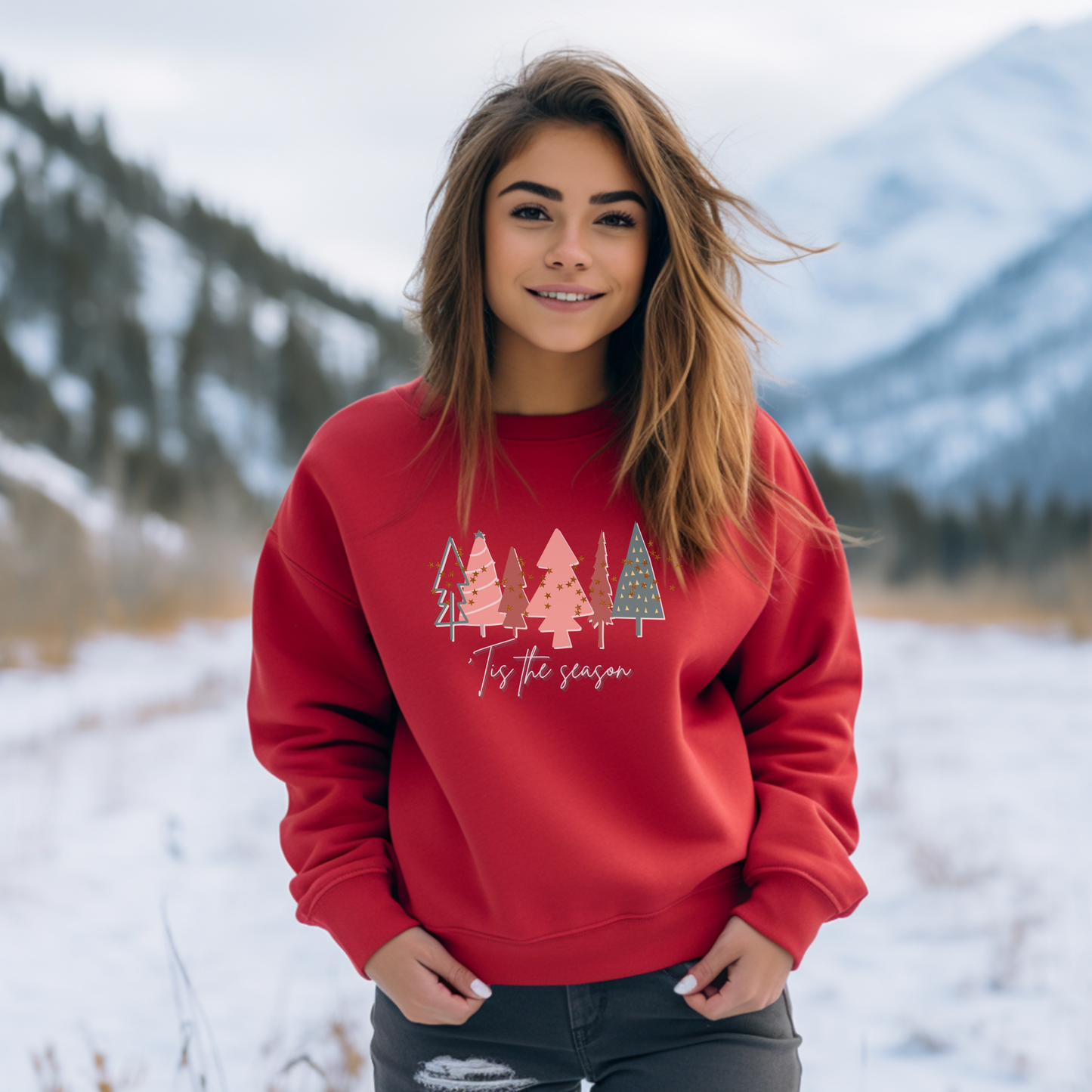 In the winter months, a cozy woman is wearing a Printify Red Christmas Tree Sweatshirt in the snow.