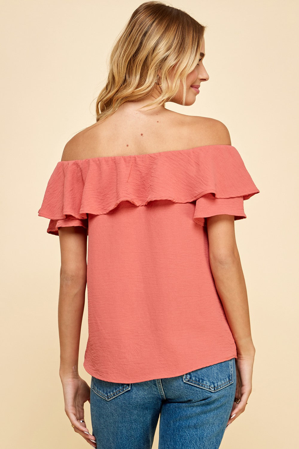 The back view of a woman wearing a Les Amis Fashion Solid Top with V Detail Off Shoulder Blouse.