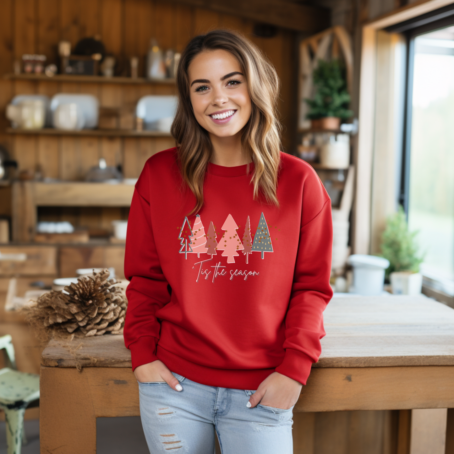 A woman wearing a cozy Printify Red Christmas Tree Sweatshirt with Christmas trees on it during the winter months.