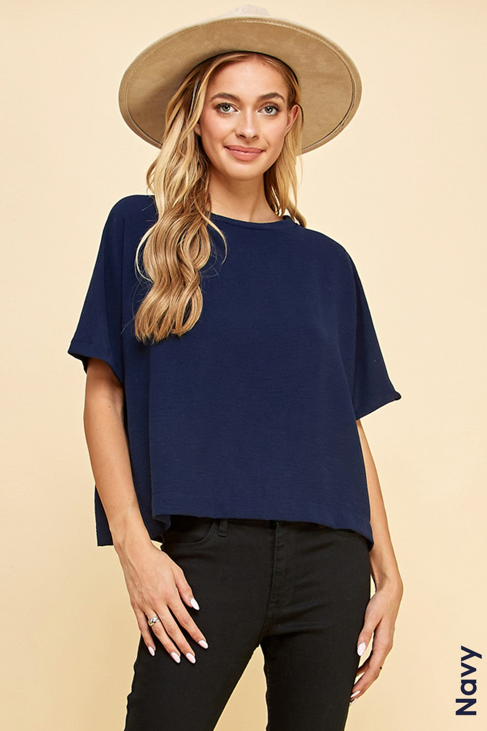 A woman wearing a hat and jeans paired with a Les Amis Fashion Navy | Solid Top 1/2 Sleeves.