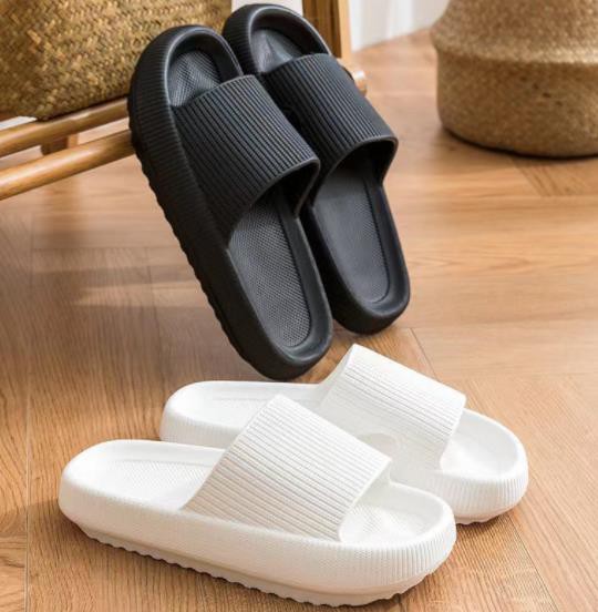 A pair of Air Cloud Sandals by Wall to Wall on a wooden floor.