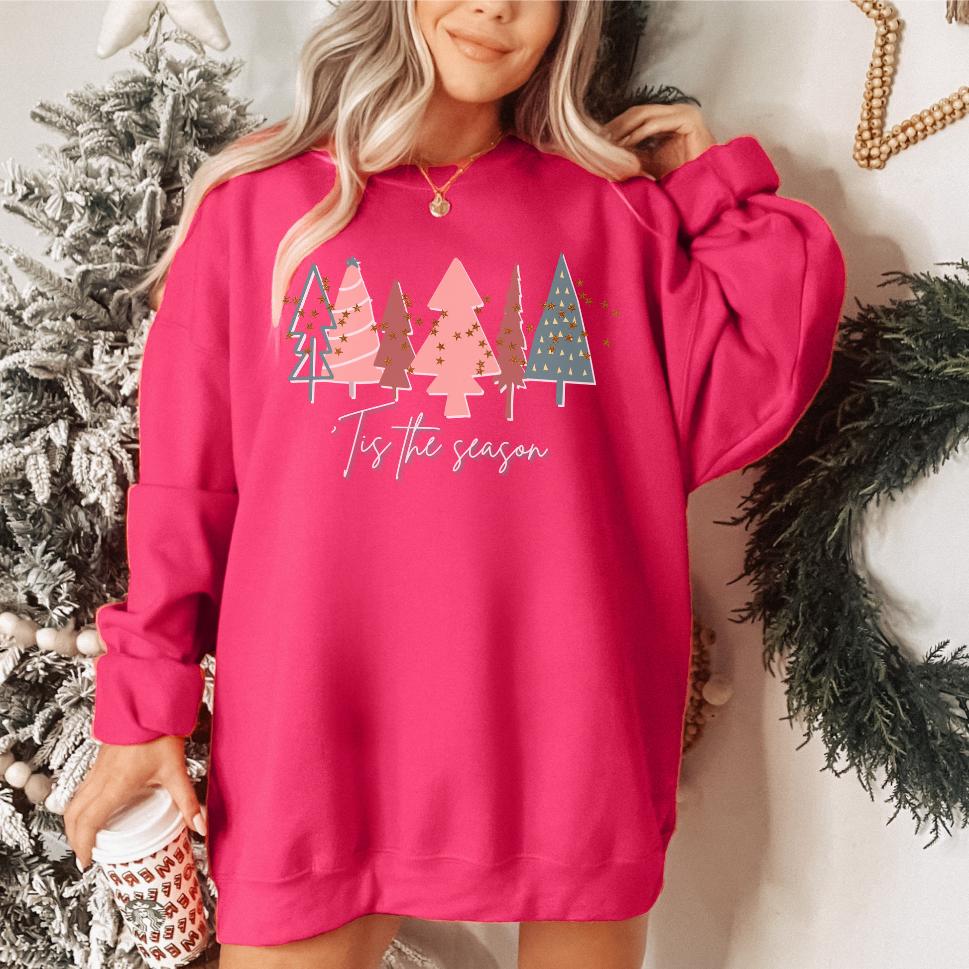A woman wearing a cozy Bright Pink Christmas Tree Sweatshirt from Printify.