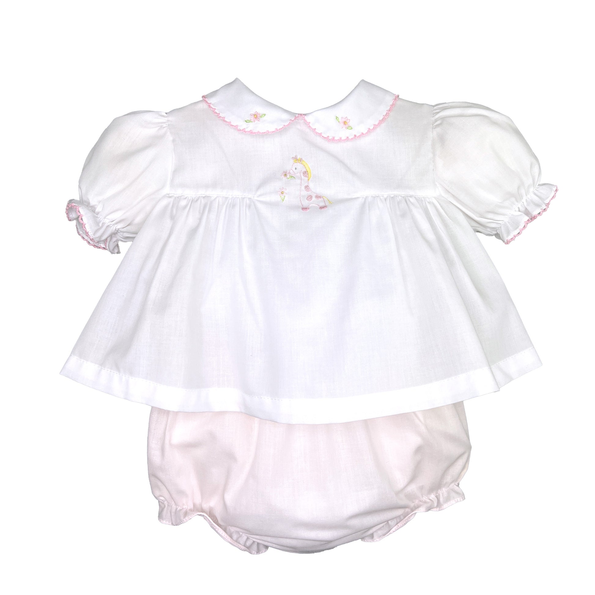 A baby girl's Petit Ami white diaper set - Giraffe with pink bonnet romper and diaper set.