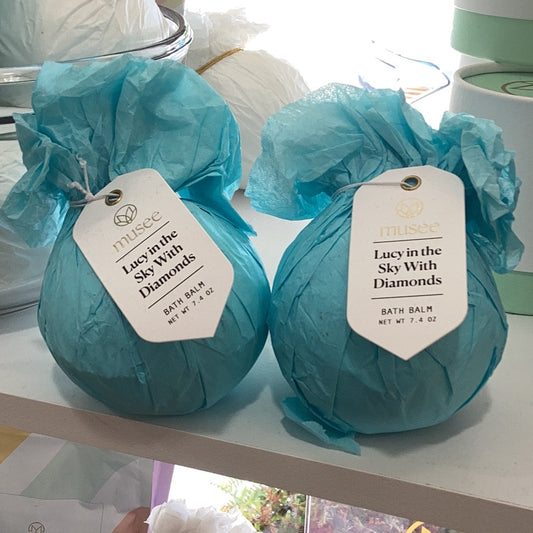 Two luxurious Lucy in the Sky with Diamonds Bath Bomb bags of soap infused with essential oils, sitting on a shelf.
