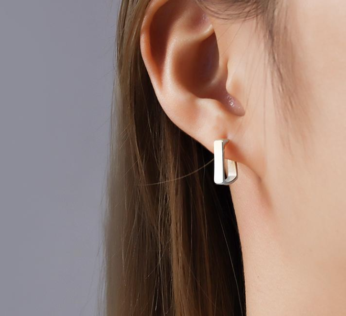 A woman's ear with a pair of WS-Predictable: Steel hoop earrings by 3Souls Company that are light weight and have a subtle flare.
