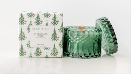 A festive green glass Christmas Woodwick Candle with a box next to it, featuring a delightful fraser fir tree scent for the holiday season, by Aroma Avenue.