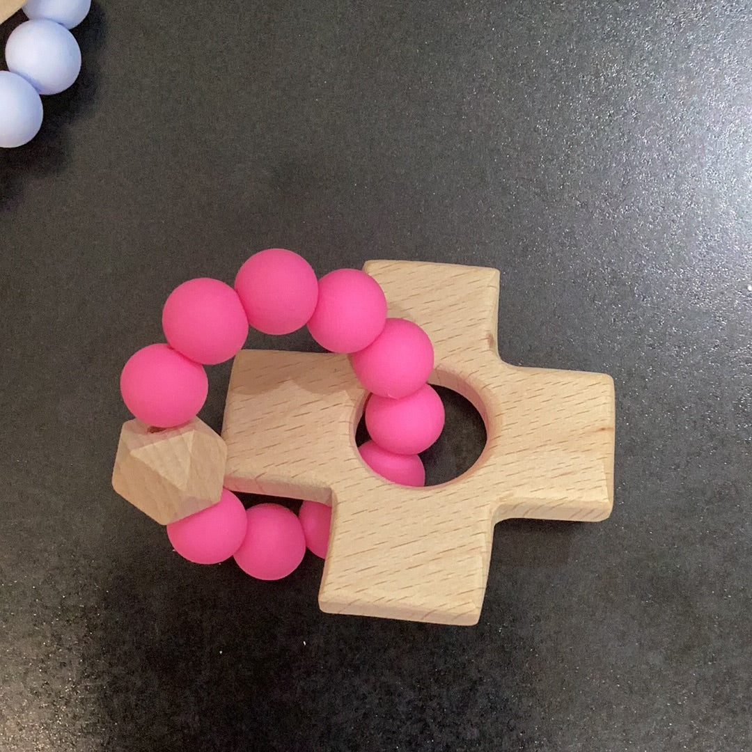 Two Cross Teethers with pink beads on them, from Chickie Collective.