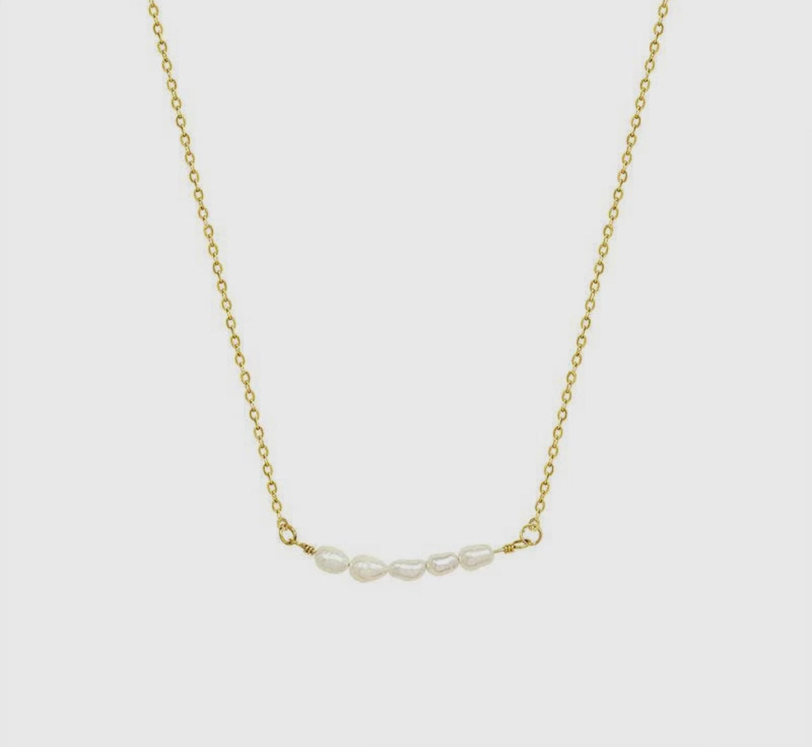 A Getaway Pearl Necklace with three pearls on it.