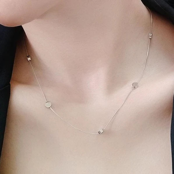 A woman is wearing a Dotti Silver Necklace from 3Souls Company with a few small stones.