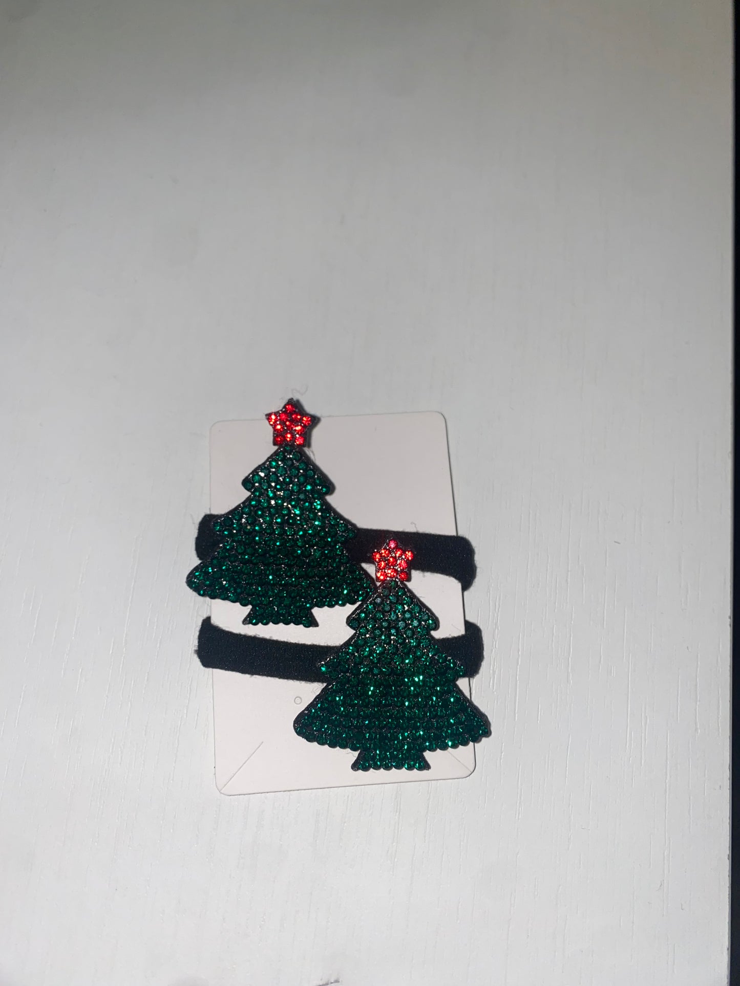 Two high-quality Chickie Collective elastic pony tail holders in a versatile and stylish Christmas tree hair clip design, placed on a white piece of paper.