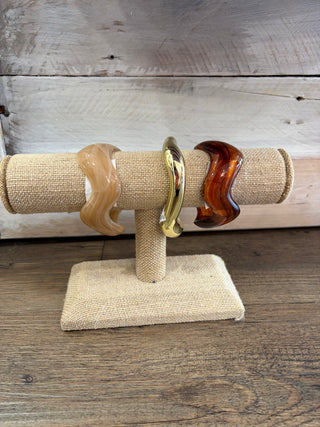 Three wavy beige, gold, and dark brown Stylish Bangle Bracelets for Women Elegant Everyday Jewelry Set bangles displayed on a T-shaped jewelry stand.