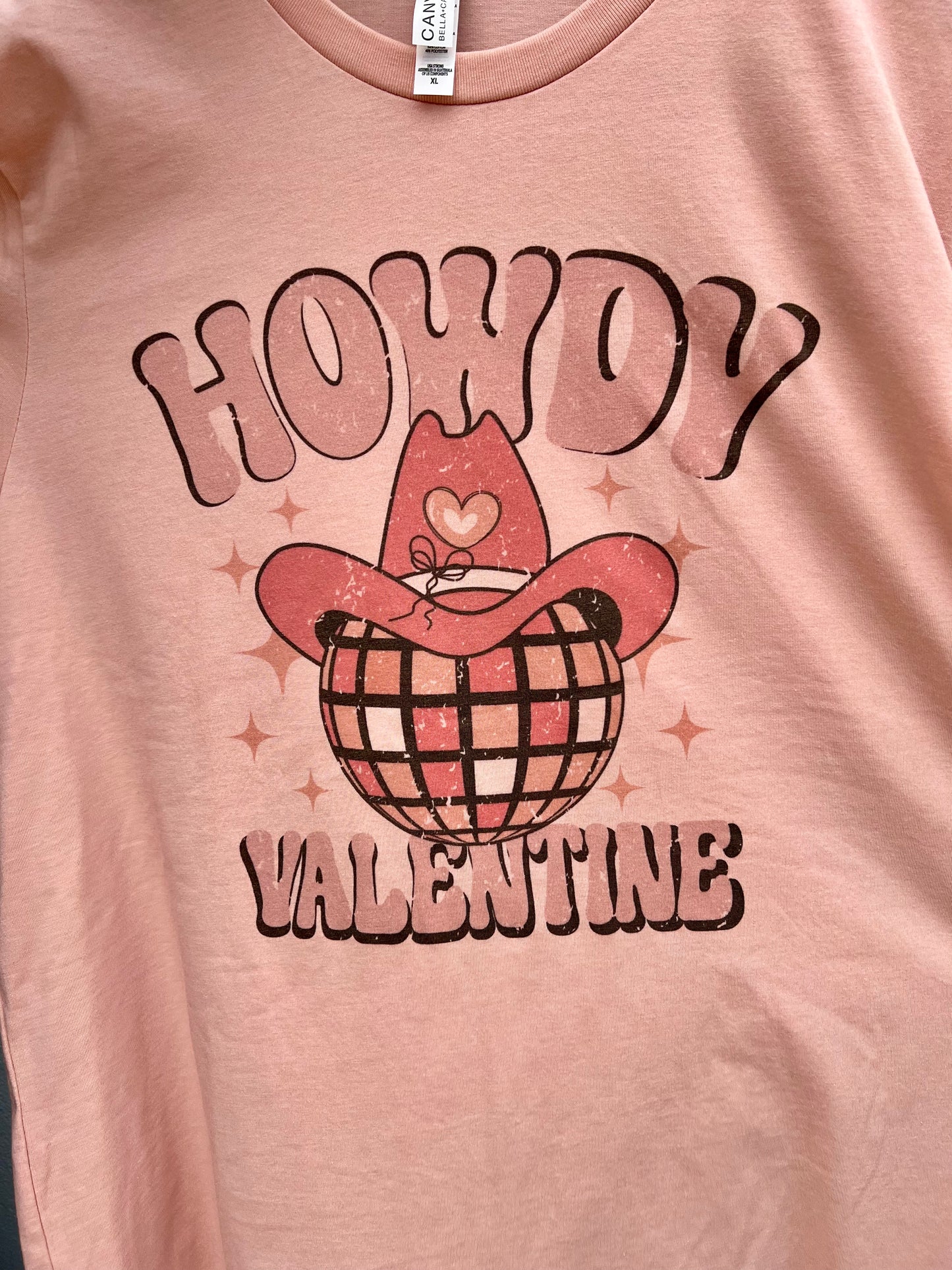 A Howdy Valentine Cowboy Disco Ball Graphic Tee with a pink cowboy Valentine design by Kissed Apparel.