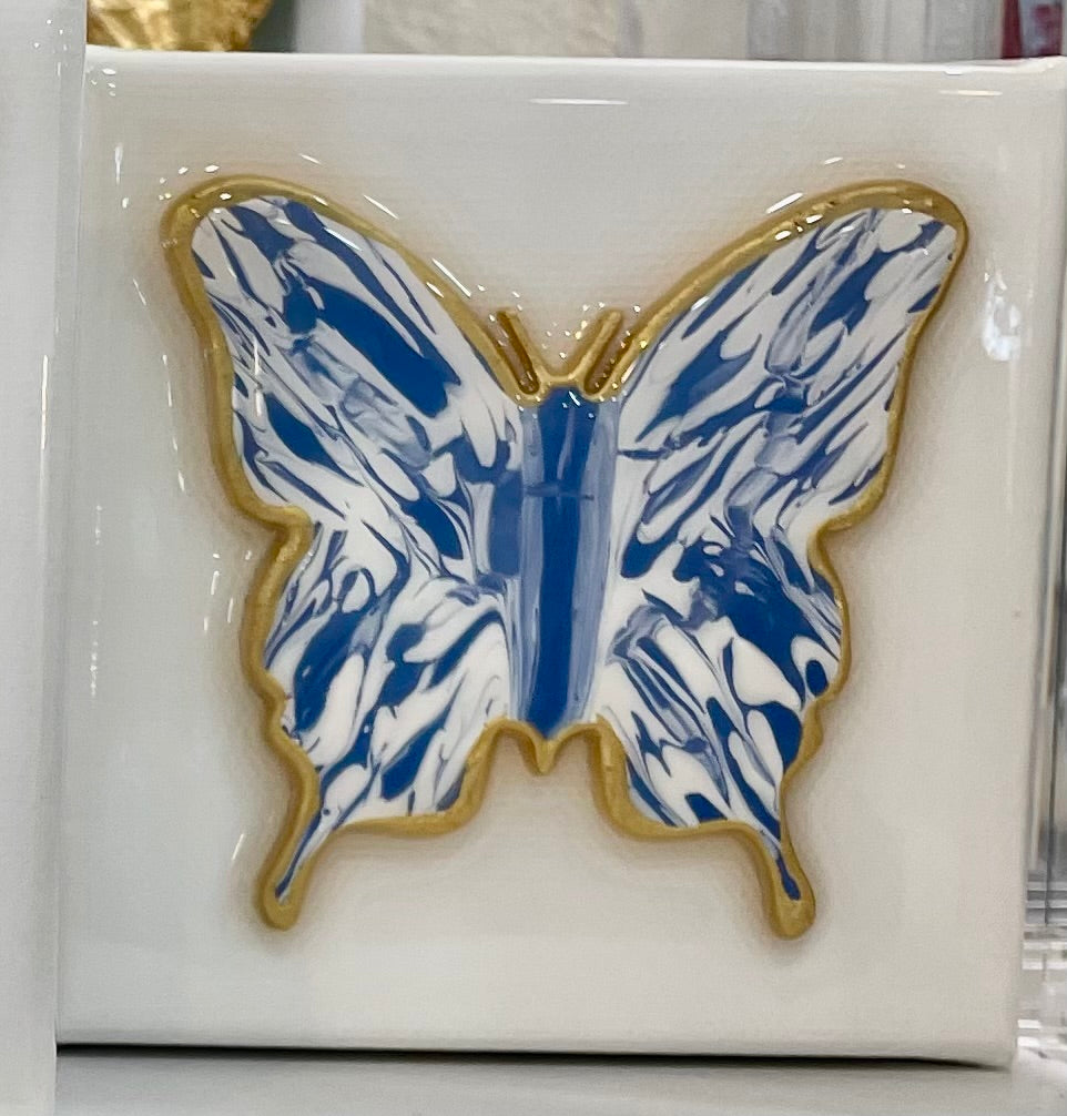 A 4x4 - Butterfly - Blue/White from Bella Gifts To Geaux on a white tile.