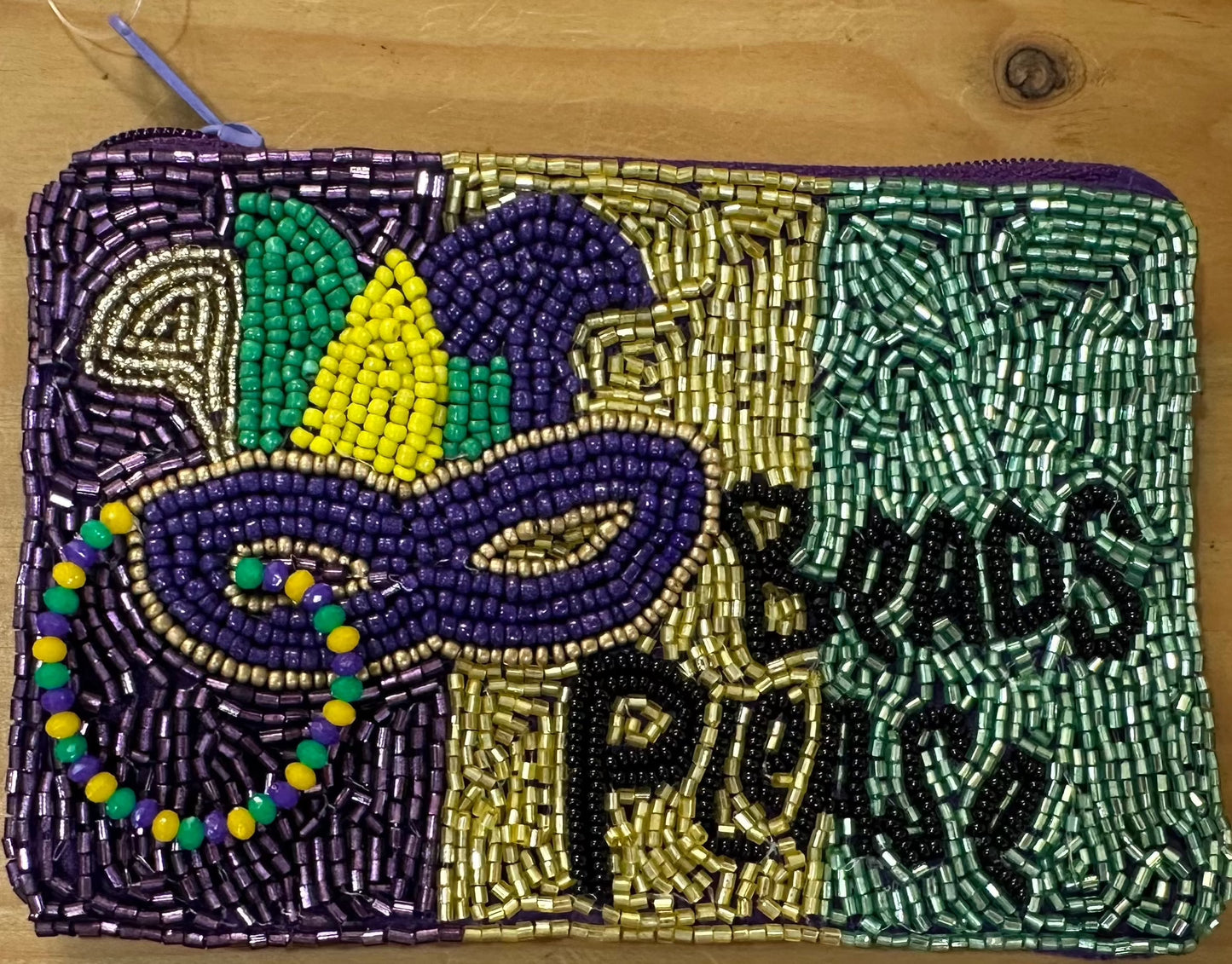 A Beads Please Beaded Coin Purse with a mardi gras design on it by Chickie Collective.
