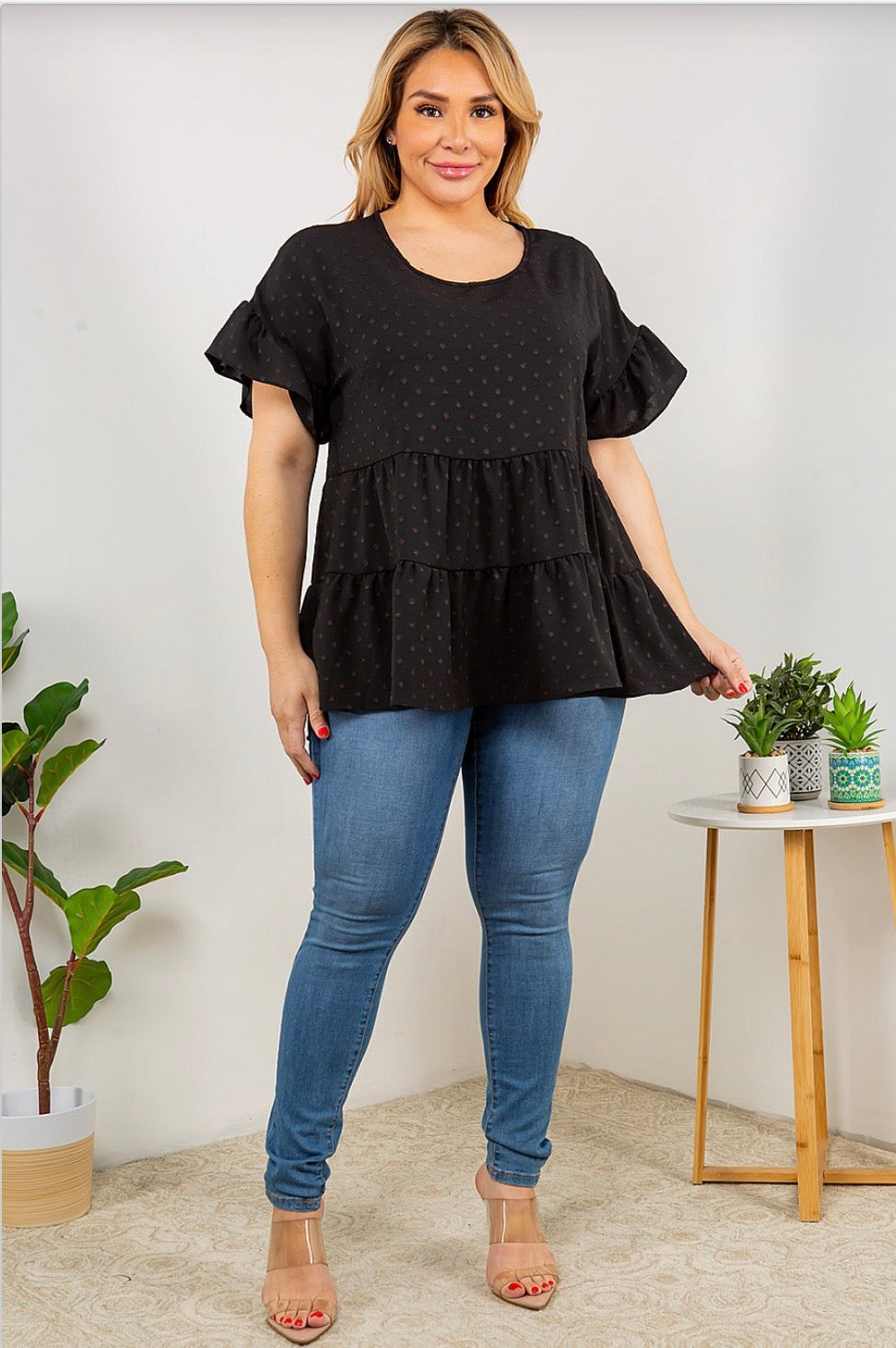 A woman wearing a Dot Ruffle Sleeve, Multi Tier Tunic Top from Spin USA and jeans.