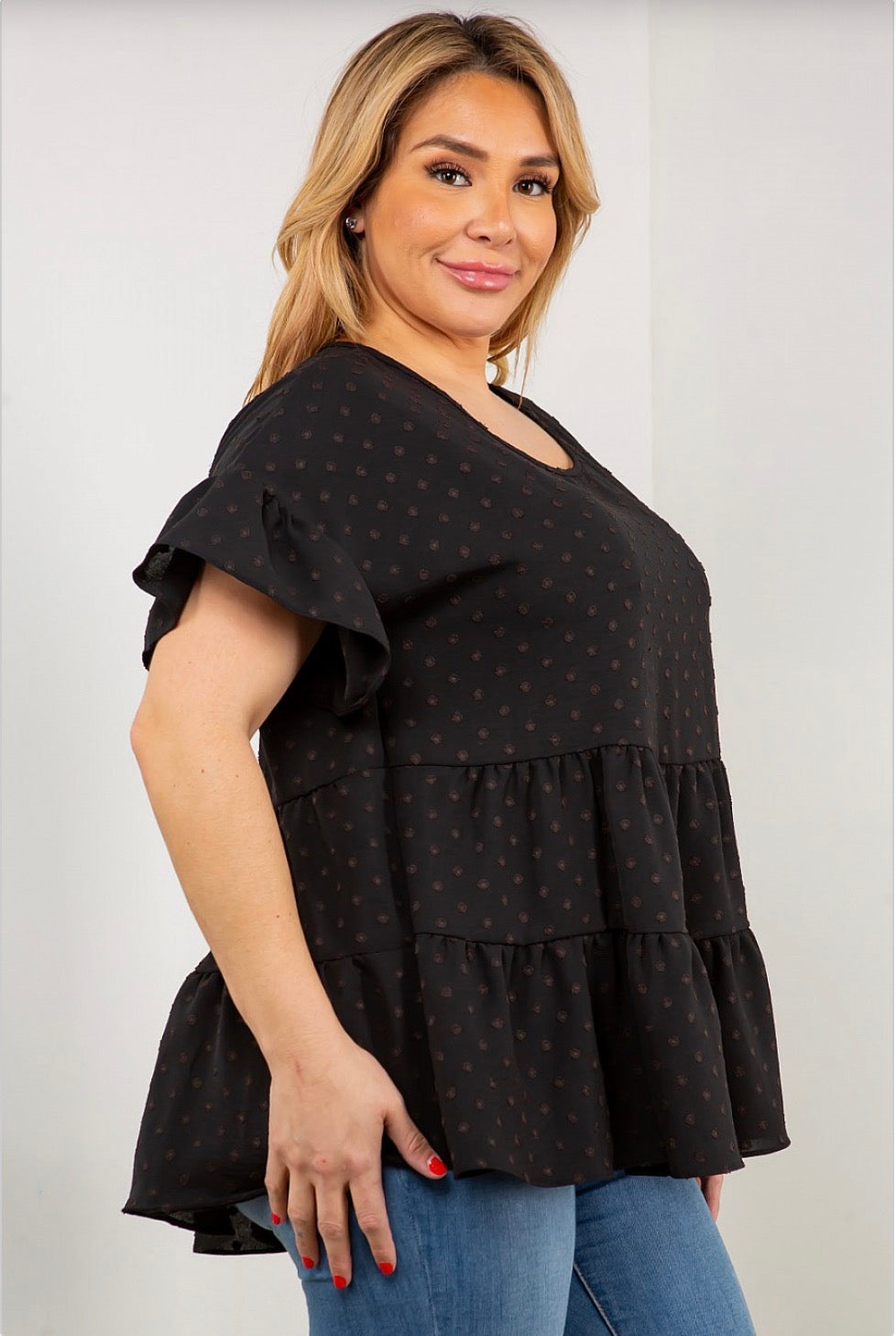 A woman wearing a Dot Ruffle Sleeve, Multi Tier Tunic Top from Spin USA.