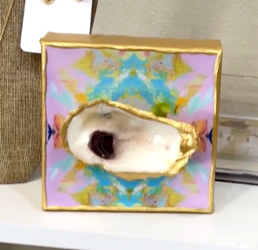 A box with a 4x4 - Glazed Oyster on Printed Canvas from Bella Gifts To Geaux sits on a shelf.