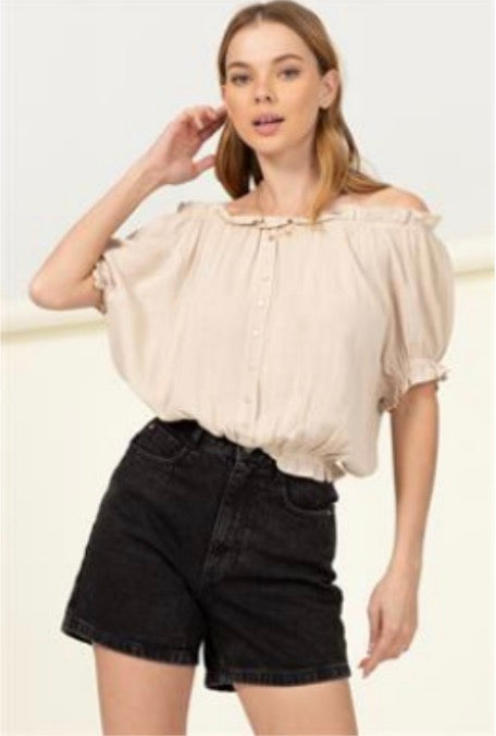 The model is wearing the Off the Shoulder Crop with Gathered Waist in beige by HYFVE and black shorts.