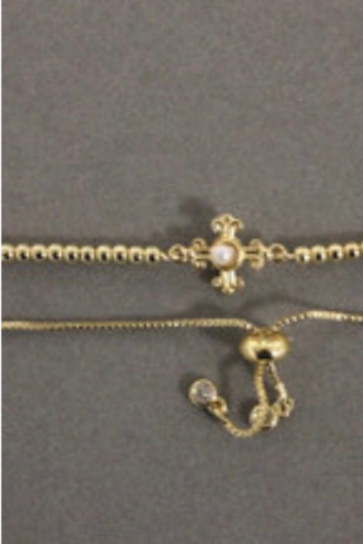 An elegant Weisinger Designs Adjustable Gold Bracelet with a pearl cross.