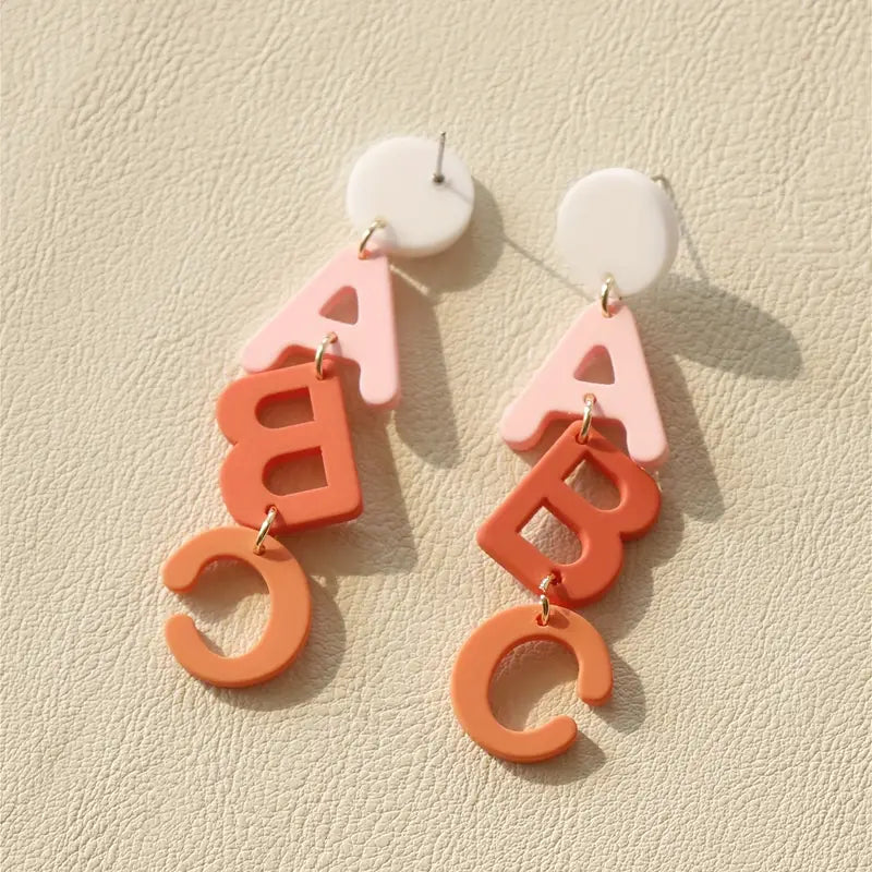 A pair of ABC Clay Dangle Earrings from Chickie Collective.