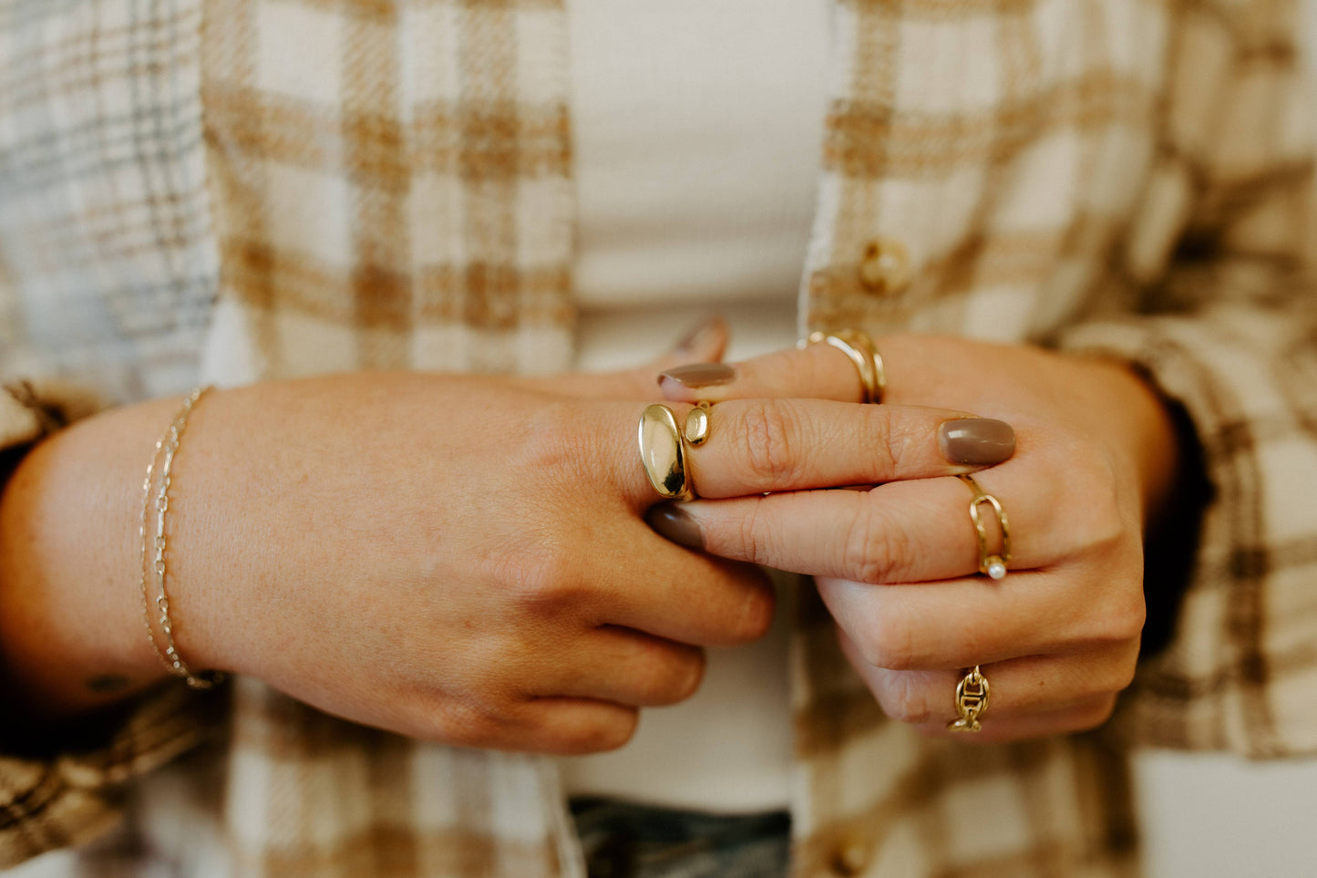 A woman wearing a plaid shirt and gold rings, showcasing the 3Souls Company WS- Geo: Silver adjustable best selling ring.