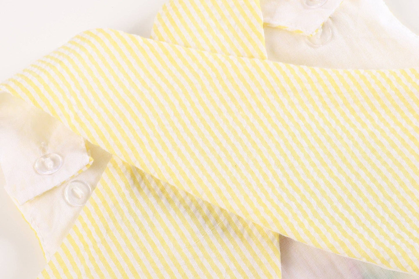An adorable Yellow Seersucker Turtle 2pc Baby Bloomer Set: 12-18M by Lil Cactus, featuring a yellow and white striped bow tie on a soft cotton white surface.