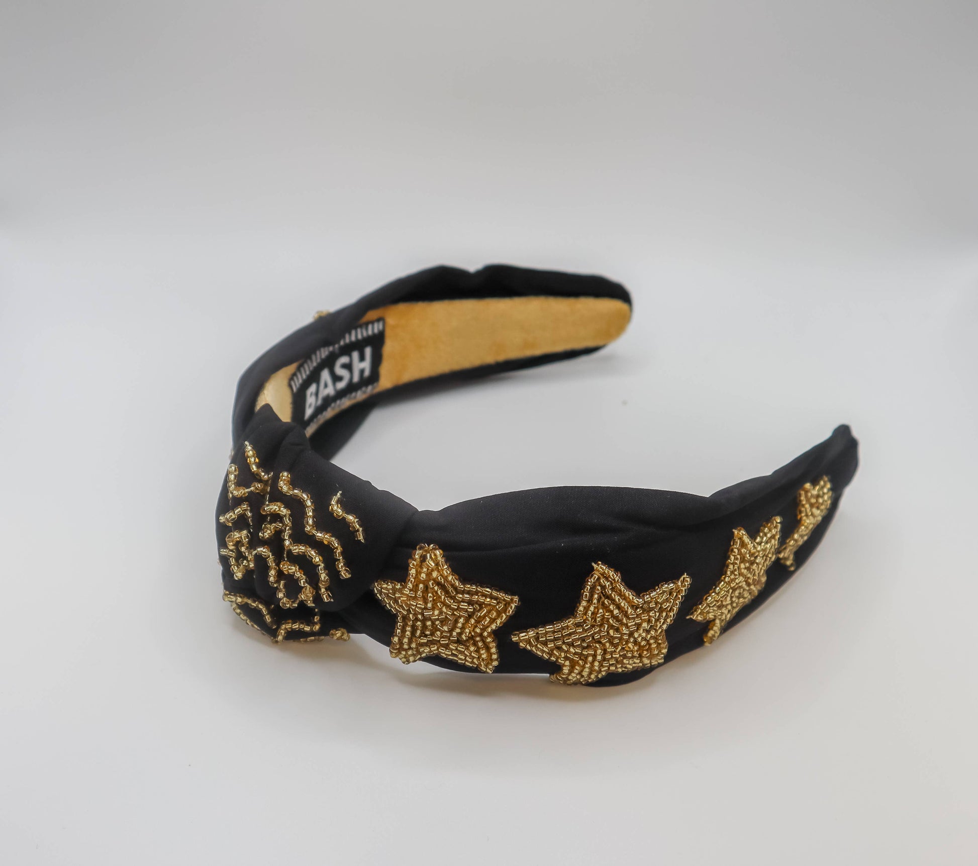 An eye-catching game day accessory, the Bash New Orleans Football Headband with Black and Gold Stars combines striking black and gold stars for a bold look.