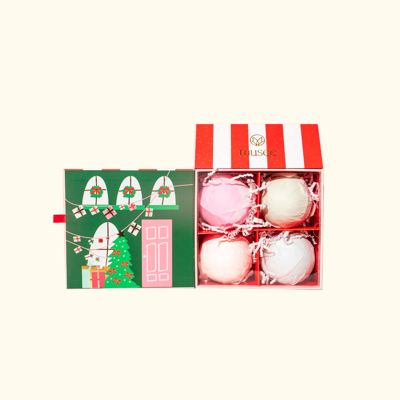 The Musee The North Pole Four Bath Balm Set, crafted by Musee, includes four bath bombs crafted with natural ingredients, each beautifully displayed in a festive box adorned with a charming christmas tree.