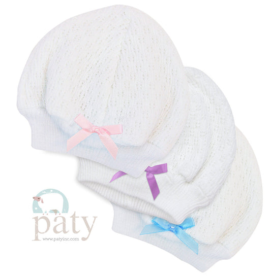 Three white Paty Beanie hats with bows on them.