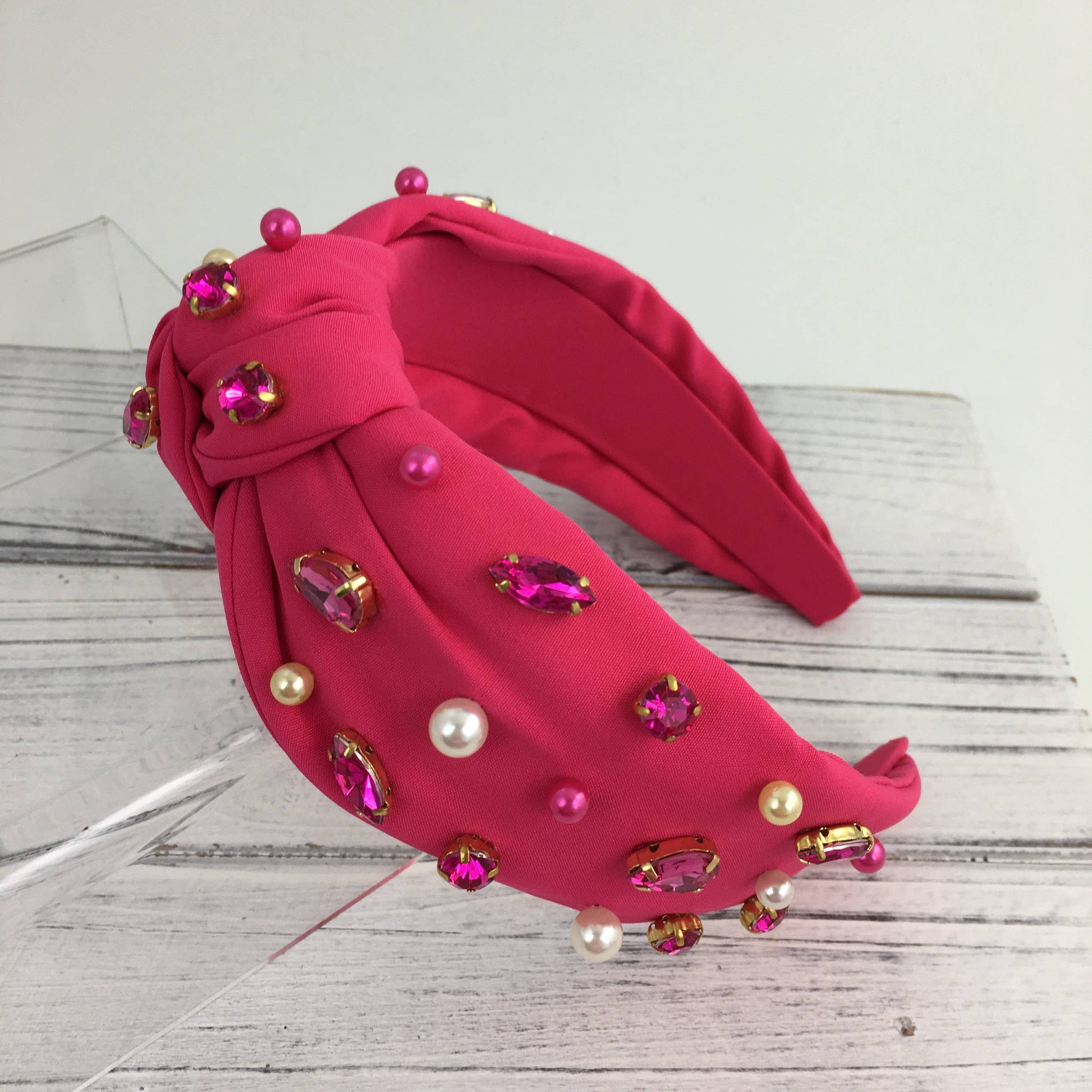 A SongLily hot pink stone/pearl fashion knot headband adorned with pearls and rhinestones.