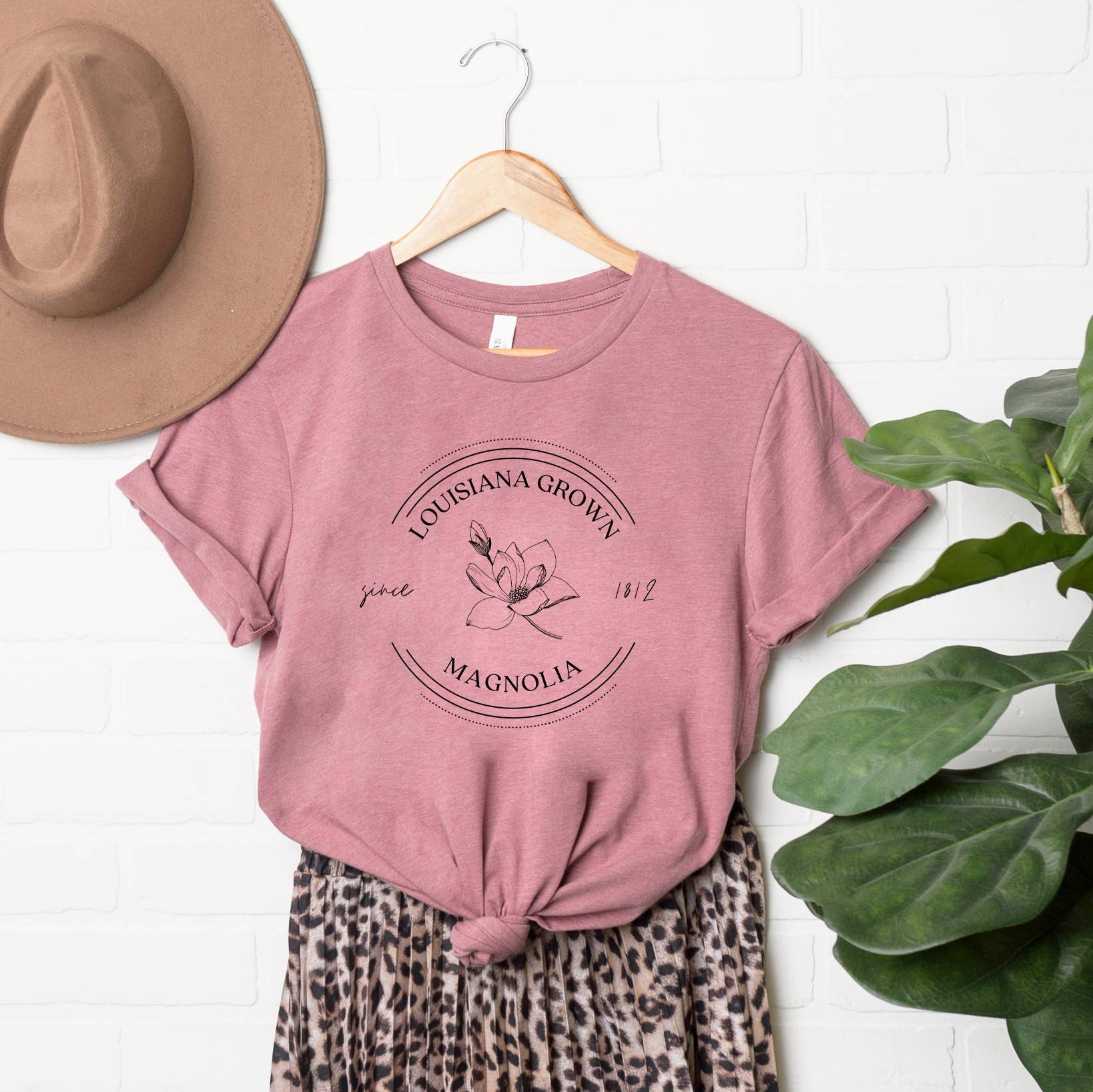 An Olive And Ivory Wholesale Louisiana State Flower Short Sleeve Graphic Tee and leopard print skirt with a hat.