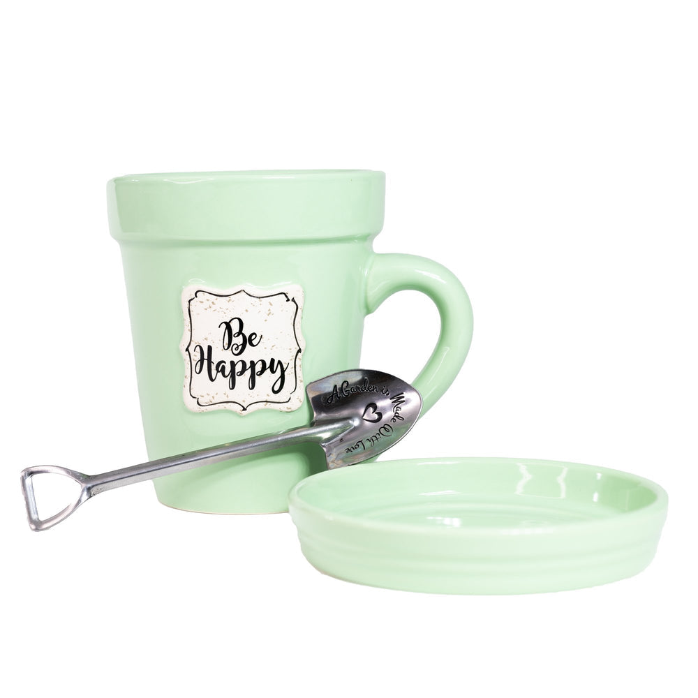 A Green Flower Pot Mug - Be Happy by Nicole Brayden with a spoon in it next to a bowl.