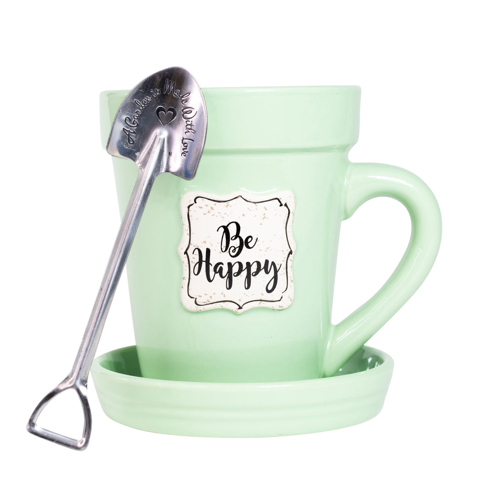 A Green Flower Pot Mug - Be Happy by Nicole Brayden with a spoon in it.