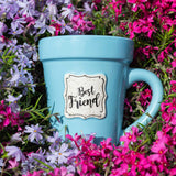 A Blue Flower Pot Mug - Best Friend by Nicole Brayden sitting in a field of purple flowers.