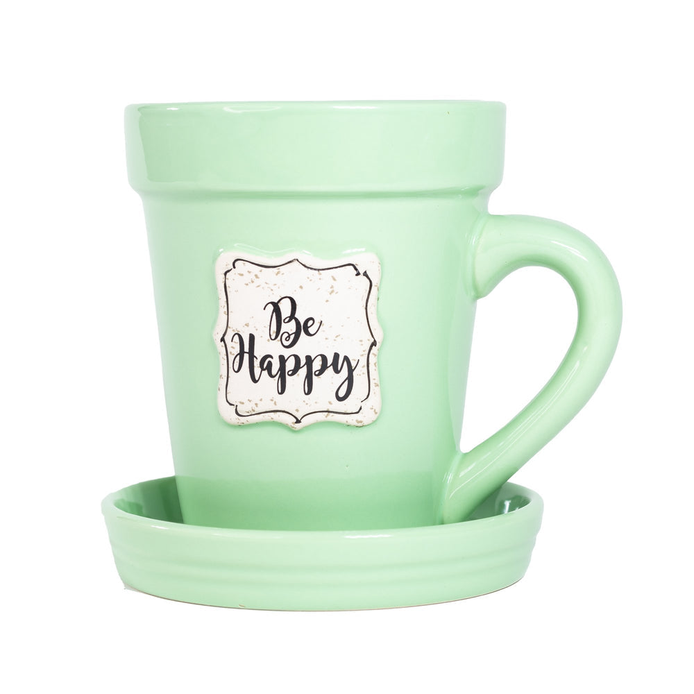 A Nicole Brayden Green Flower Pot Mug with a sticker saying Be Happy.