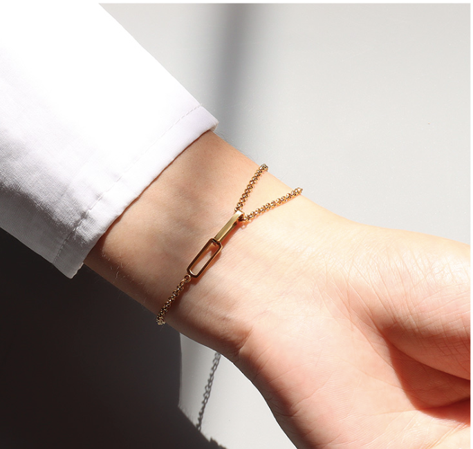 A woman's wrist adorned with an elegant 3Souls Company WS- Tangled Bracelet: Gold.