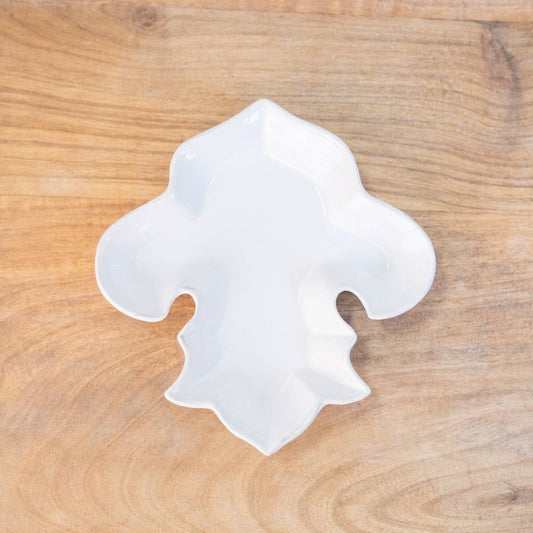 A LaFleur Shaped Tidbit Dish in white from The Royal Standard, sitting on top of a wooden table.
