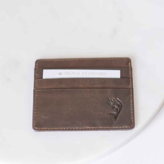 A Fish Leather Embossed Slim Wallet in Dark Brown by The Royal Standard with a white card.