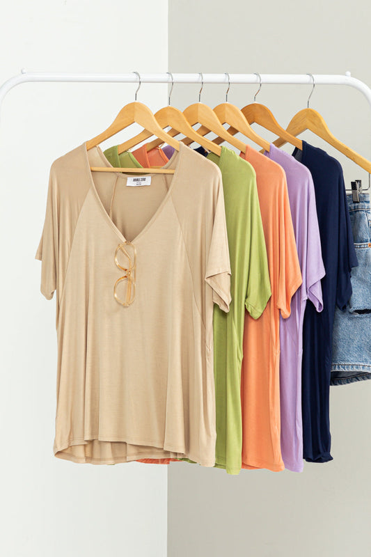 An oversized HYFVE short sleeve top hanging on a clothes rack.