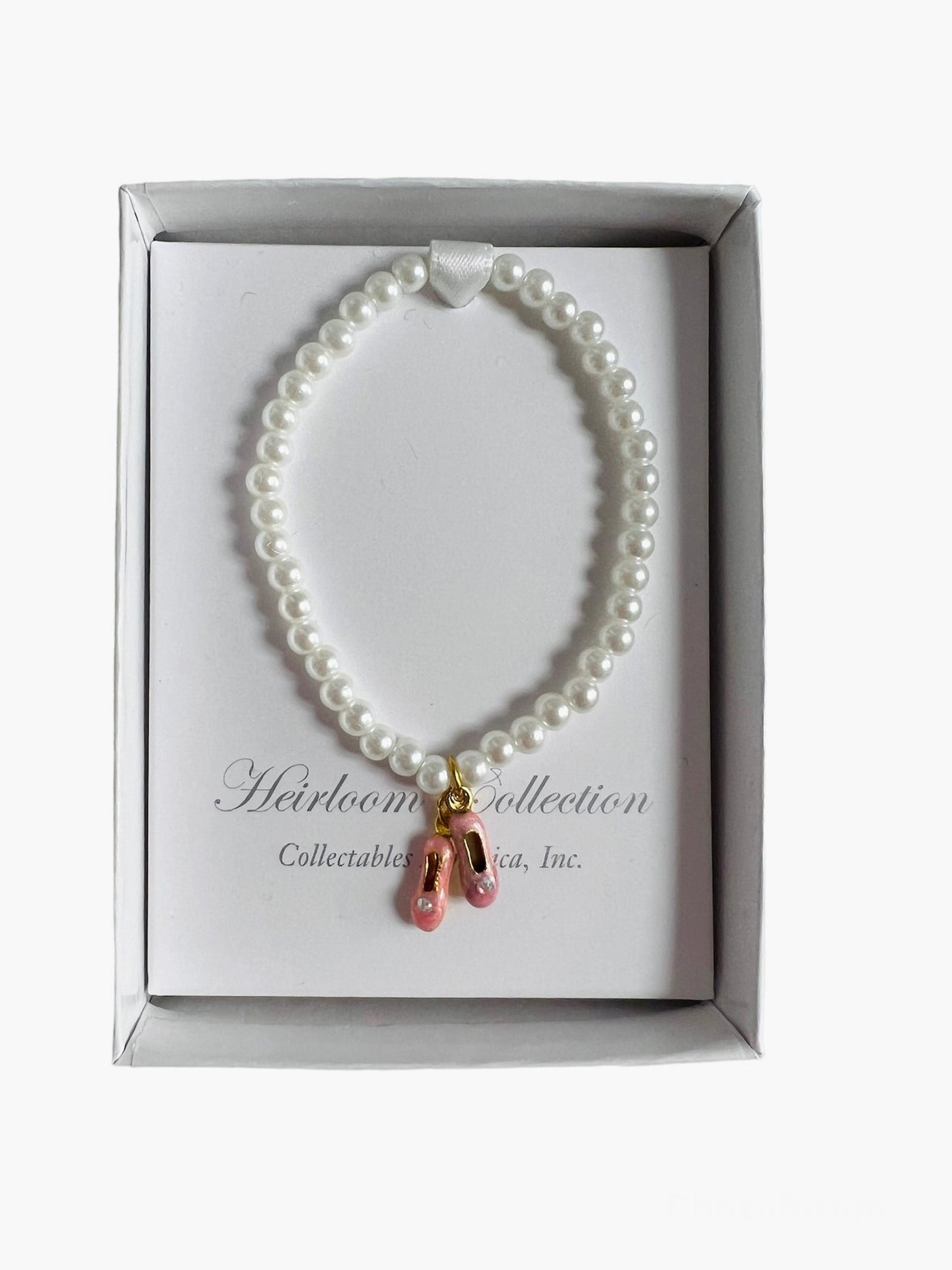 A Pink Pearl Ballet Shoe Bracelet with a gold charm by Collectables America.